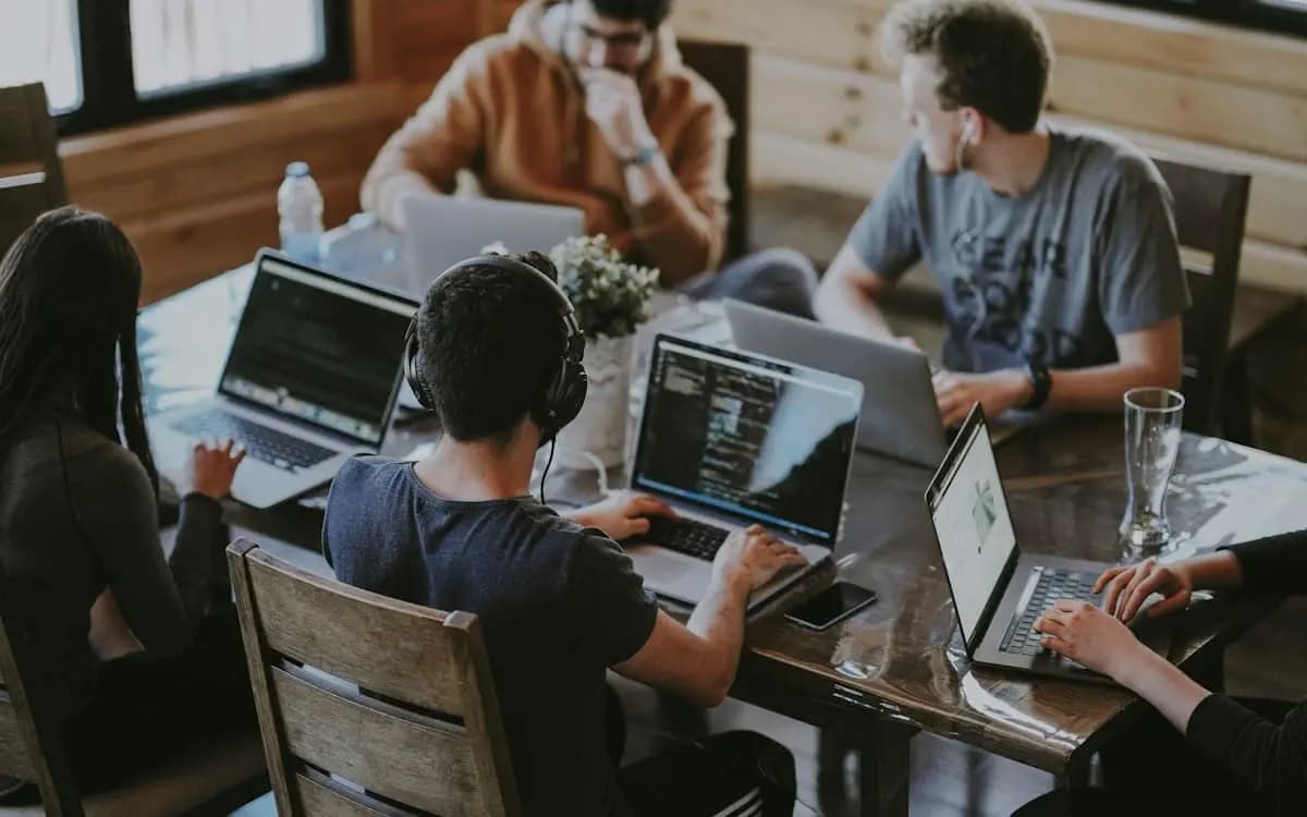 Team collaborating at laptops during a coordinated call handoff workflow